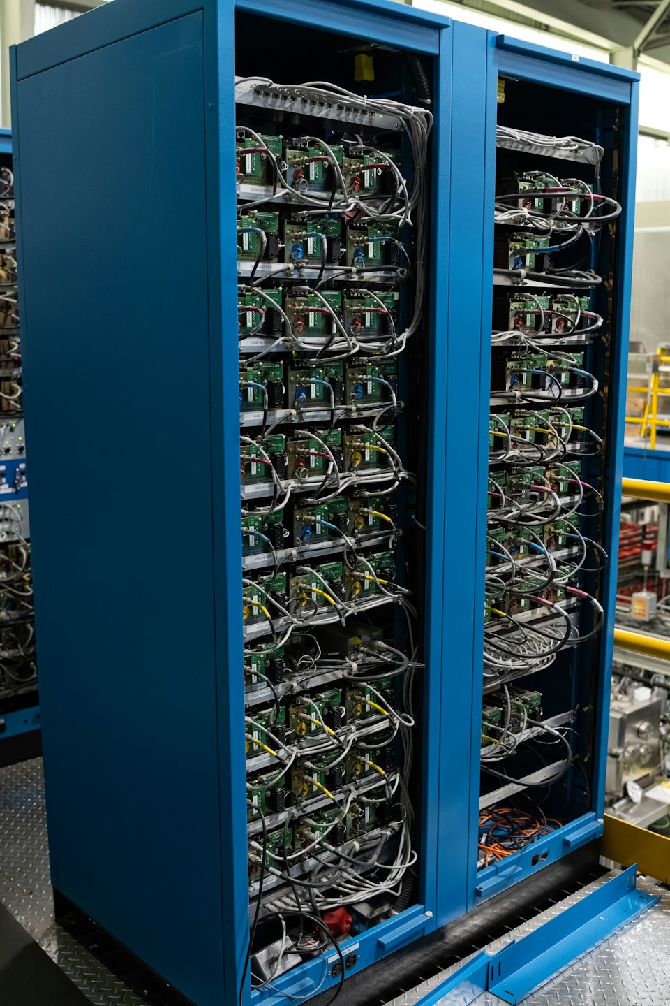 Open server racks filled with interconnected electronic components and cables.