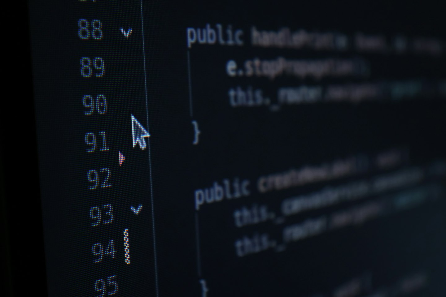 Computer monitor displaying lines of programming code with a mouse cursor.